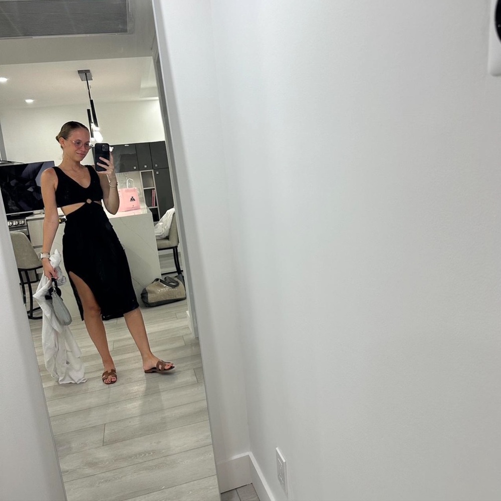 Black knit midi dress with open back and split hem.
